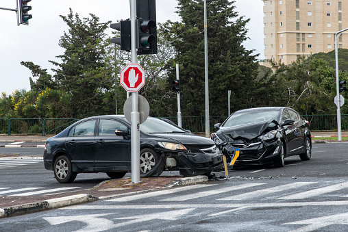 A crash at an intersection involving two cars that have been badly damaged