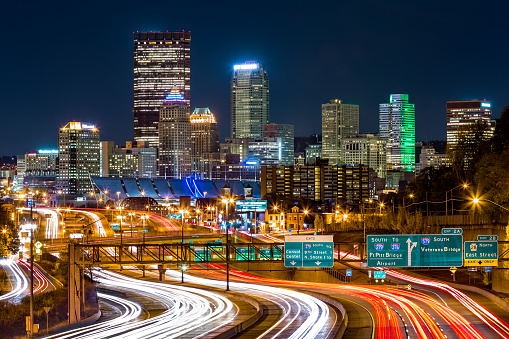 Pittsburgh skyline by night. The rush hour traffic leaves light trails on I-279 parkway