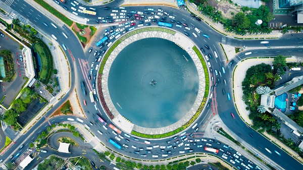 Aerial view of a roundabout in a city with traffic flowing in at different entry points.